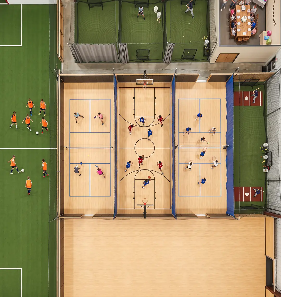 Overhead view of a sports facility with turf, courts, batting cages and a party room all booked at once